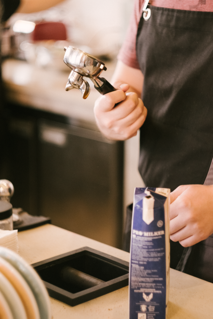Barista holding a portafilter preparing coffee in a café