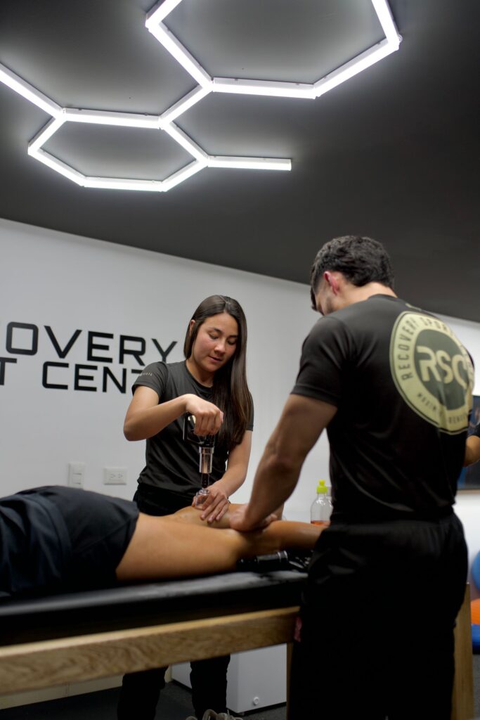 Two physiotherapists treating a patient in a modern clinic