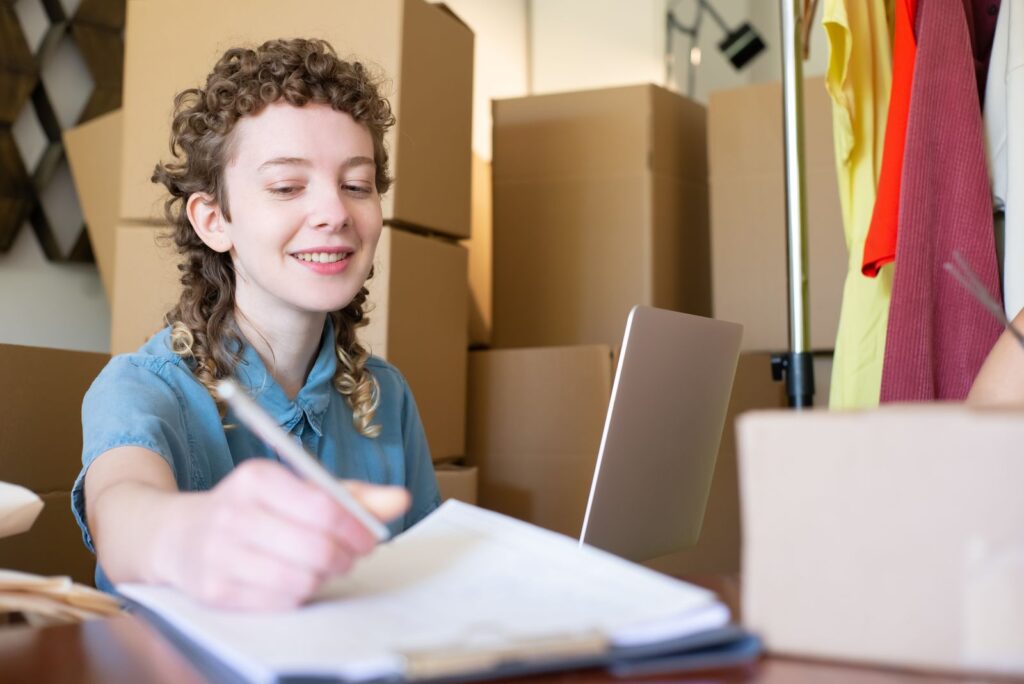 Small business owner at a desk with a laptop and packages