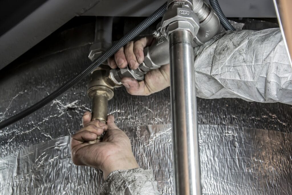 Plumber installing pipe fittings with a wrench